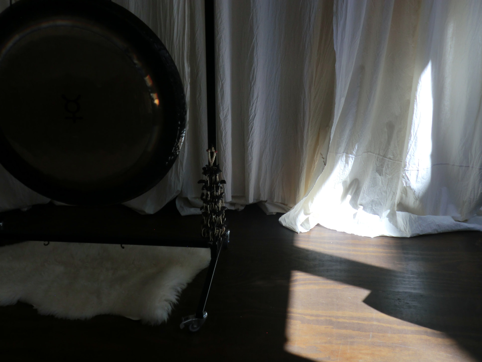 a gong resting against soft white curtains