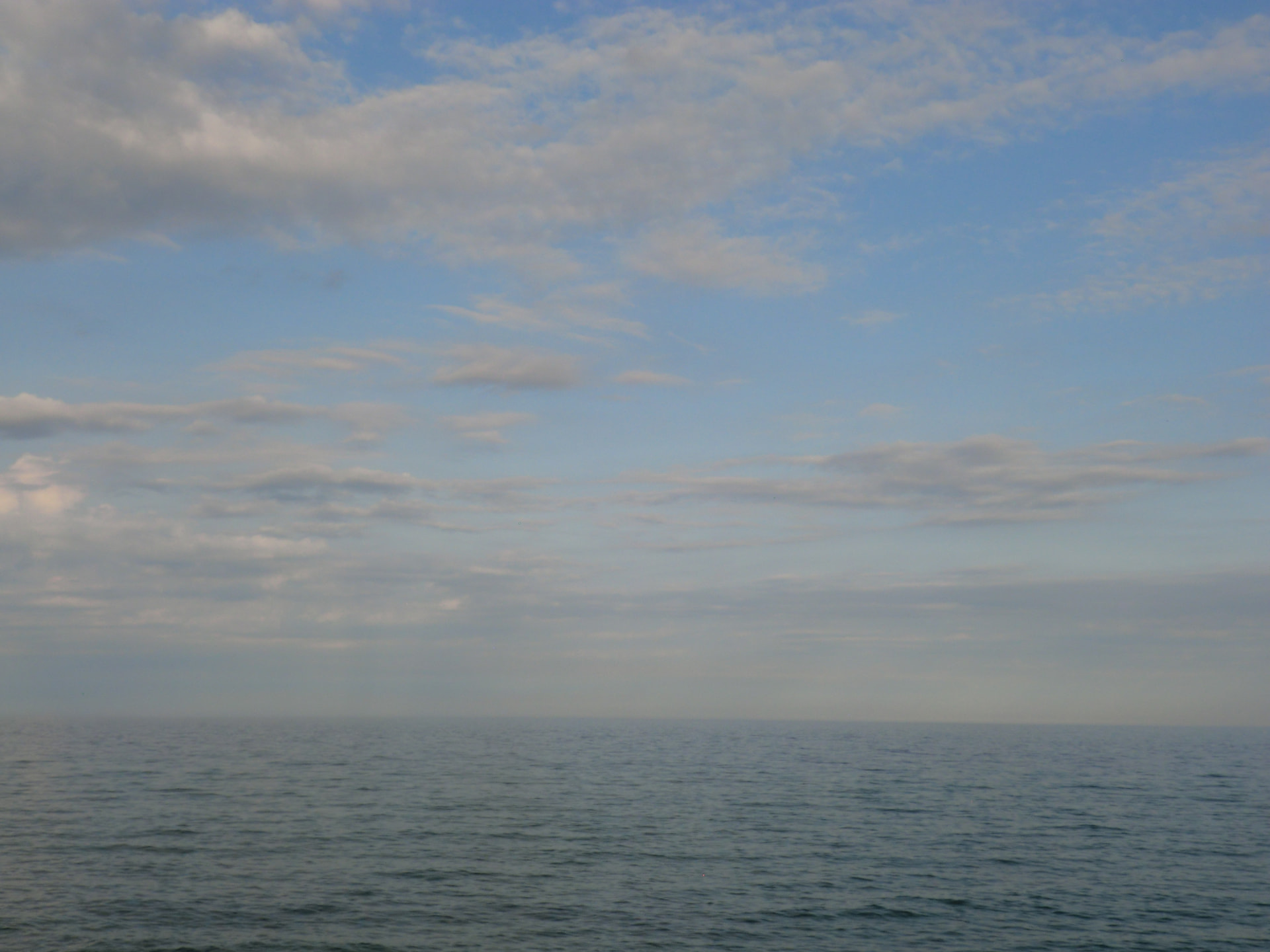 calm sea meeting a wide, cloudy sky